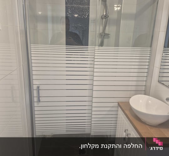 מקלחון הזזה מבוסס זכוכית פסים לצד ארון אמבטיה
